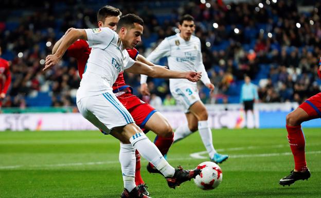 Lucas, golpea el balón y al fondo se ven los aficionados con sus móviles encendidos 