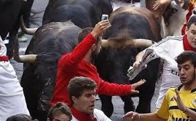 Temeridad en el encierro. Imprudente desconocido. Logró lo que quería. Se hizo un ‘selfie’ mientras corría delante de un toro en el encierro del 12 de julio de 2014 en Pamplona, pero también le sacaron una foto que dio la vuelta al mundo y le costó al desconocido corredor un aluvión de críticas por su inconsciencia.
