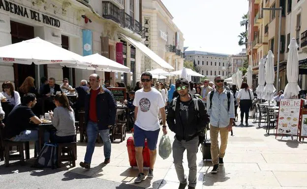 Turistas avanzan con sus maletas por la calle Alcazabilla en busca de la vivienda en la que se alojan. 