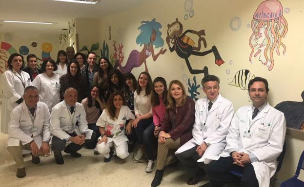 La delegada de Igualdad, Salud y Políticas Sociales, Ana Isabel González, junto a los profesionales del servicio de radiodiagnóstico y jóvenes que han participado en la creación de este mural.