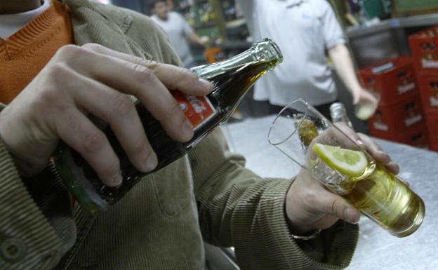 Un cliente se sirve una copa en un bar (archivo).