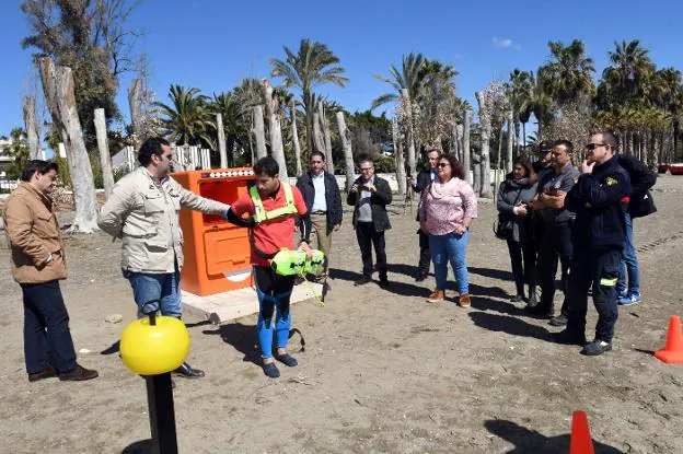 Un socorrista explica el funcioamiento del dispositivo con el edil de playas. 