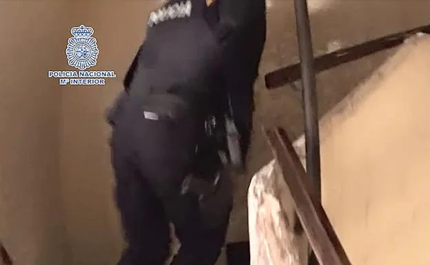 Un policía nacional durante el asalto a la vivienda de los detenidos, en Alicante.