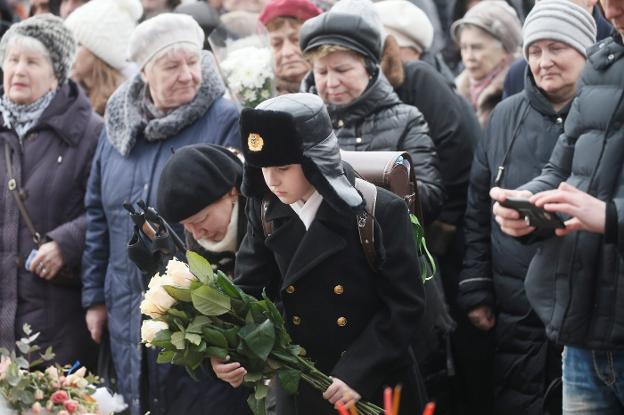 Un niño realiza una ofrenda floral en Moscú en memoria de los fallecidos. :: Maxim Shipenkov / efe