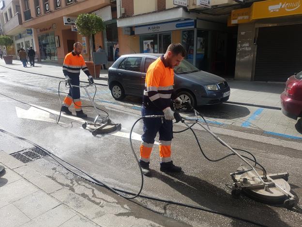 Operarios de la limpieza retiran la cera de las calles. 