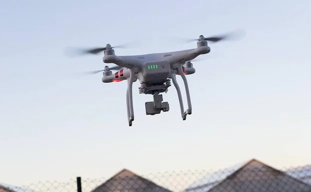 Un dron Phantom sobrevolando un grupo de casas. 