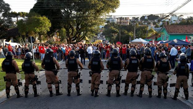 Seguidores de Lula protestan ante las instalaciones de la Policía Federal en Curitiba, protegidas por los antidisturbios. :: /Rodolfo Buhrer / reuters