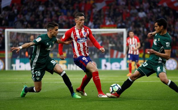 Fernando Torres, encimado por dos futbolistas del Betis. 