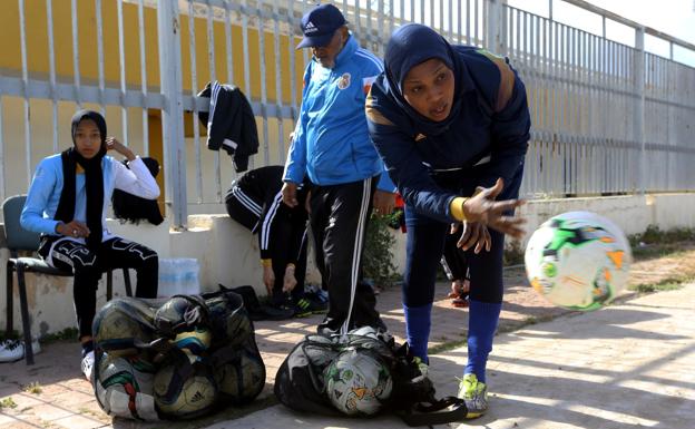 Una mujer prepara los balones para comenzar el entrenamiento. 