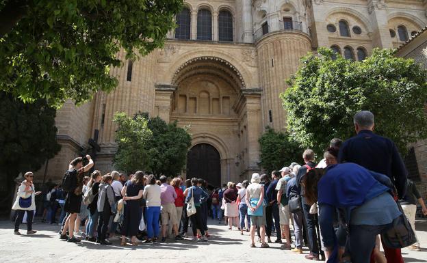 Colas de turistas al mediodía de ayer en el Patio de los Naranjos para acceder a la Catedral de Málaga.