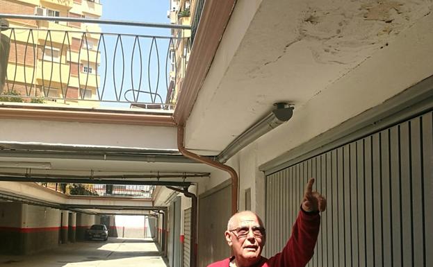José Cortes señala las humedades que se producen en el aparcamiento del Pasaje Virgen de Belén.