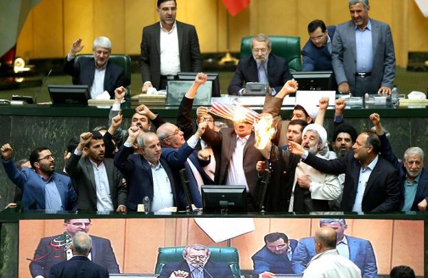 Un grupo de diputados quema una bandera de papel de EE UU en los escaños del Parlamento iraní. :: afp
