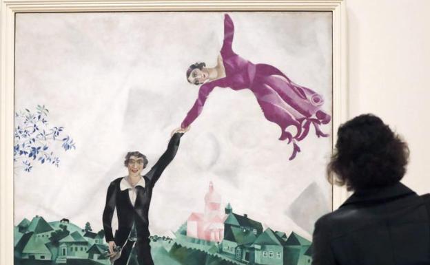 Una mujer observa la obra 'Paseo', de Chagall. 