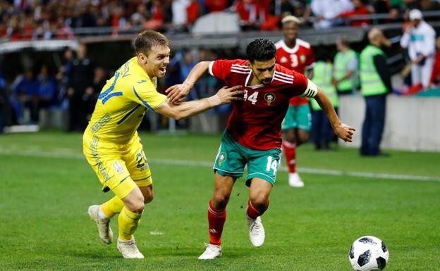 El marroquí Mbark Boussoufa y el ucraniano Oleksandr Karavayev se disputan el balón en un momento del partido.