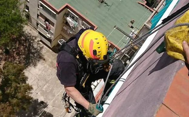 Un bombero trata de acceder a una vivienda desde el tejado. 