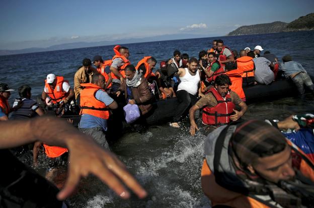 Refugiados sirios tratan de saltar a un bote tras llegar a la isla griega de Lesbos. :: Alkis Konstantinidis  / reuters