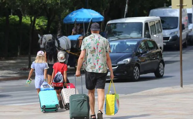 Viajeros, con maletas en mano, se dirigen hacia su alojamiento. 