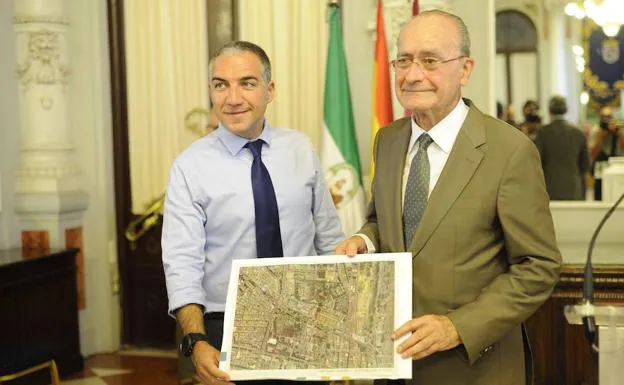 Francisco de la Torre y Elías Bendodo muestran un plano del terreno en el que irá ubicado el hospital. 