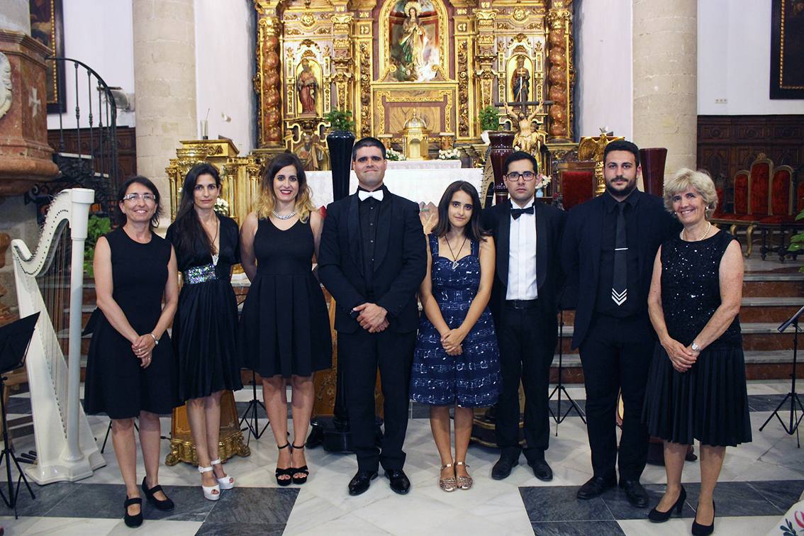 La Orquesta de Arpas celebra un concierto en la Iglesia San Juan Bautista de Coín. Componentes de la Orquesta de Arpas de Málaga posan en una foto de familia.