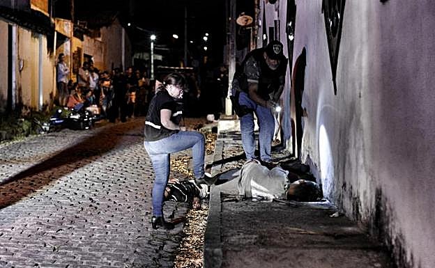 Miembros de las fuerzas del orden mientras investigan un doble homicidio