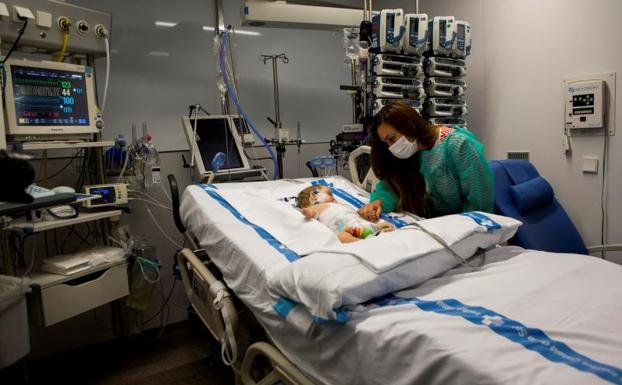 Vanesa cuida a su hija Roma, una de los dos trasplantadas hepáticas mediante el procedimiento 'quirúrgico split'.