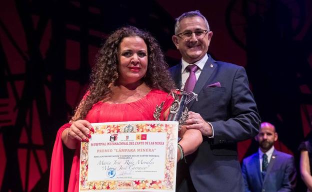 María José Carrasco recibe el premio que la acredita como ganadora.