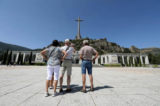 Un grupo de turistas fotografía los monumentos del Valle de los Caídos, que ayer registró una afluencia de visitantes superior a la habitual. :: j. j. Guillén / efe