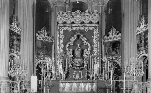 El exorno del altar de la novena de la Patrona alcanzó todo su esplendor cuando pasó a situarse en el centro del presbiterio de la Catedral. En el año de esta fotografía se emplearon para su iluminación los grandes candelabros de madera que flanqueaban el vestíbulo del hotel Málaga Palacio.. 