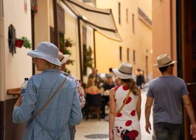 Imagen secundaria 1 - Un grupo de viajeros disfruta del paseo marítimo. Turistas conocen el Centro de Málaga. La operación retorno de vacaciones arrancó ayer.