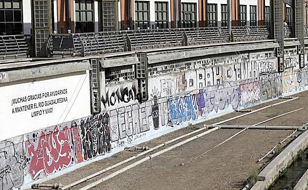 Los grafitis se suceden uno tras otro en el tramo del cauce junto a los hoteles del Perchel norte. 