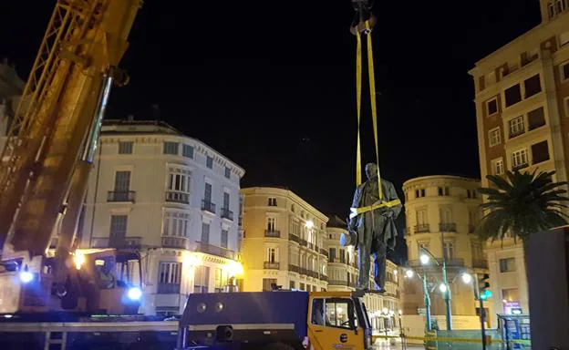 Momento en el que han bajado esta mañana de su pedestal la escultura del Marques de Larios 