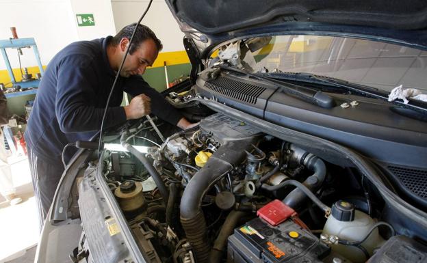 Un mecanico revisa el interior de un vehiculo en un taller de reparación de coches 