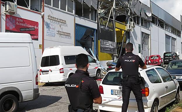 Agentes de la Policía Nacional, junto a las naves afectadas, en un polígono industrial de San Pedro Alcántara . 