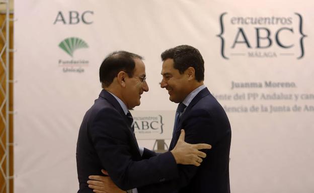 Juanma Moreno saluda al presidente de la Confederación de Empresarios de Andalucía, Javier González de Lara, en el acto. 