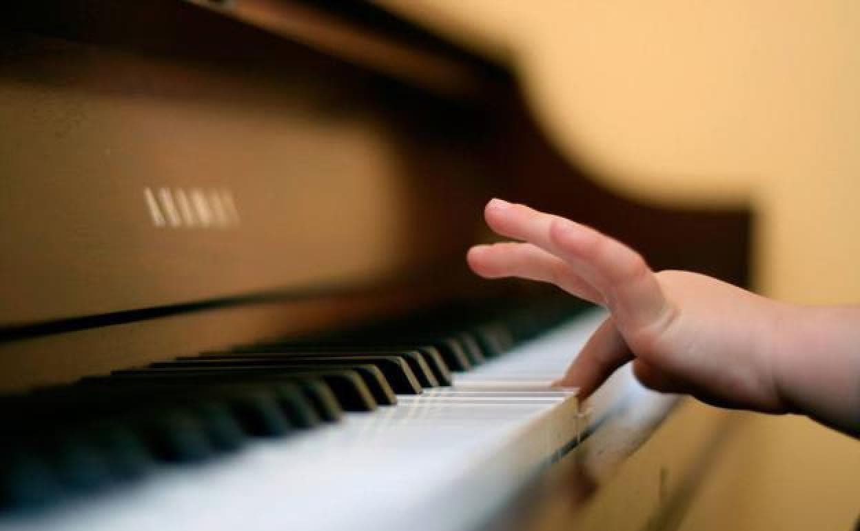 Un niño toca el piano.