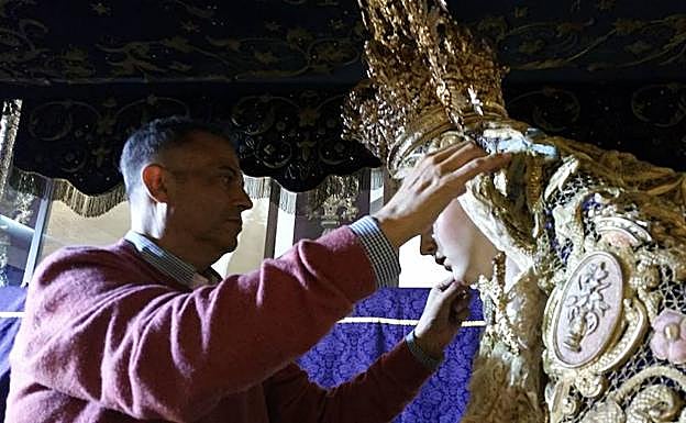 Jesús Frías retoca la vestimenta de la Virgen del Amor en su trono procesional. 