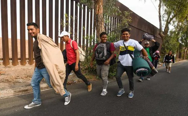 ecenas de migrantes centroamericanos caminan hoy junto a la valla fronteriza de la ciudad norteña de Mexicali rumbo a la ciudad de Tijuana. 