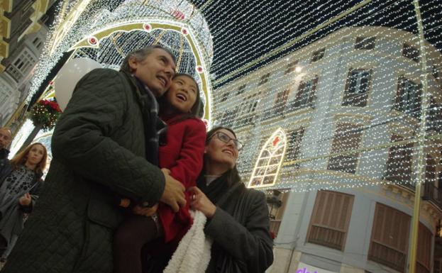 Una familia observa el espectáculo del alumbrado navideño.