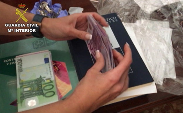 Una agente realiza el recuento del dinero intervenido.