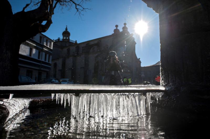 Fuentes heladas, termómetros bajos y mucha ropa de abrigo, lo más destacado en ciudades como Valencia, Pamplona, León, Ourense o Ávila