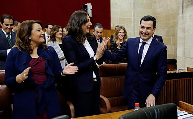 Carmen Crespo, en el centro, aplaude la intervención de Juanma Moreno.