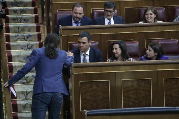 Pedro Sánchez y Pablo Iglesias se saludan cómplices en el Congreso el pasado mayo durante la moción de censura contra Rajoy. :: zipi / efe