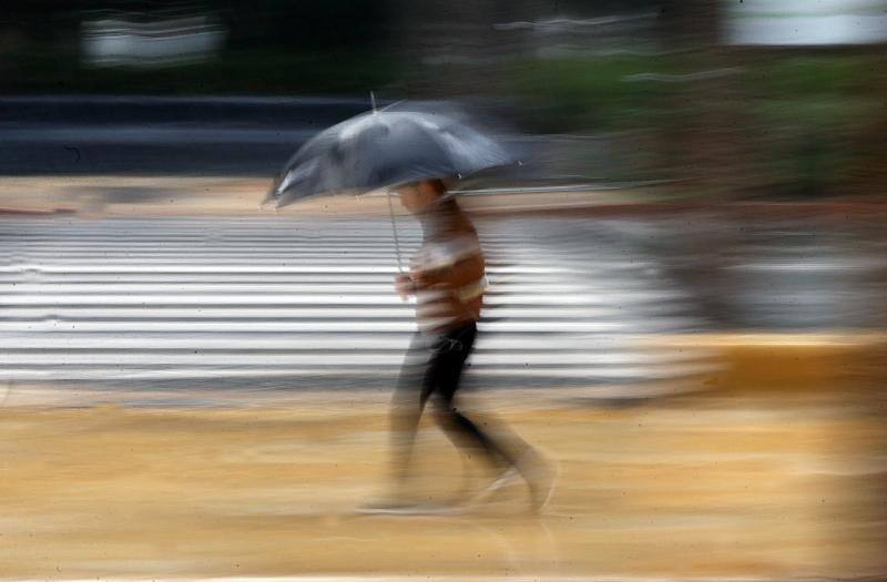 Un ciudadano se resguarda de la lluvia, este viernes, en la capital.