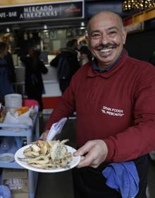 Imagen secundaria 2 - Turistas y visitantes almuerzan en el interior del Mercado de Atarazanas. Abajo, el Mercado del Carmen. El pescaíto frito es la estrella en las cartas.