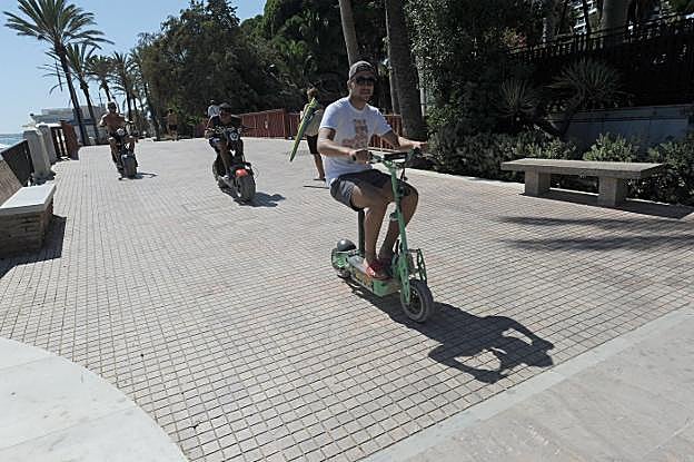 Usuarios de vehículos de movilidad personal por el paseo marítimo. 