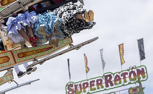 Chicas con vestidos flamencos disfrutan de la noria en la Feria de Abril de Sevilla. 