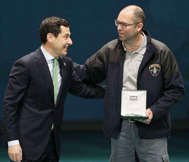 El presidente andaluz, Juanma Moreno (i), entrega al representante de la Brigada Central de Salvamento Minero la Medalla de Andalucía, durante el acto de entrega hoy con motivo del día de la comunidad autónoma