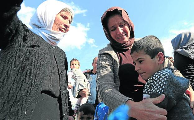 Un niño yazidí es recibido por sus familiares tras ser rescatado por las fuerzas kurdas que combaten en Siria al Estado Islámico.