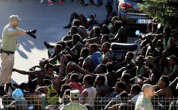 Inmigrantes en el lado marroquí de la valla que divide España y Marruecos.