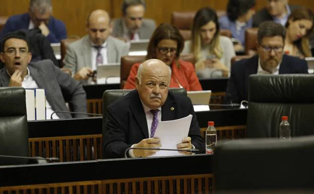 El consejero de Salud, Jesús Aguirre, sentado en su escaño delante de la bancada socialista, con su portavoz, Mario Jiménez, detrás. 